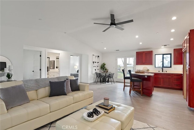 living area with lofted ceiling, recessed lighting, light wood-type flooring, and ceiling fan