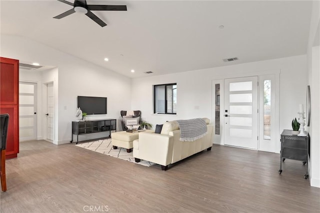 living room with visible vents, a ceiling fan, lofted ceiling, and wood finished floors