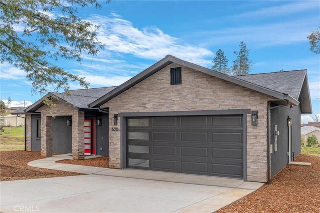 ranch-style home with stone siding, an attached garage, concrete driveway, and roof with shingles