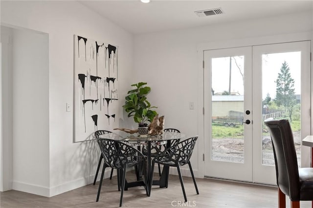 dining area featuring visible vents, french doors, light wood-type flooring, and baseboards