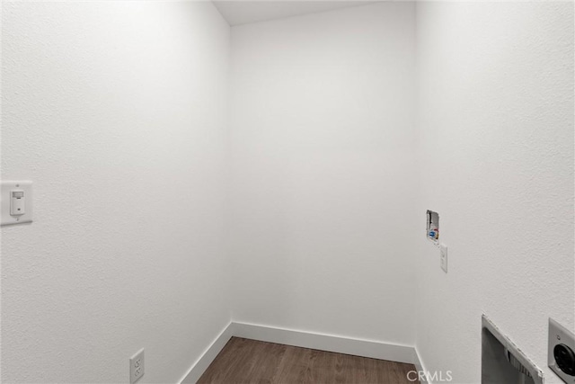 laundry room with baseboards, dark wood-type flooring, and laundry area