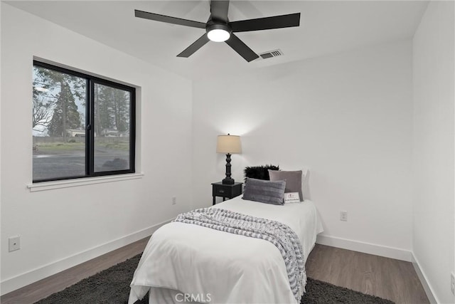 bedroom with visible vents, ceiling fan, dark wood-type flooring, and baseboards