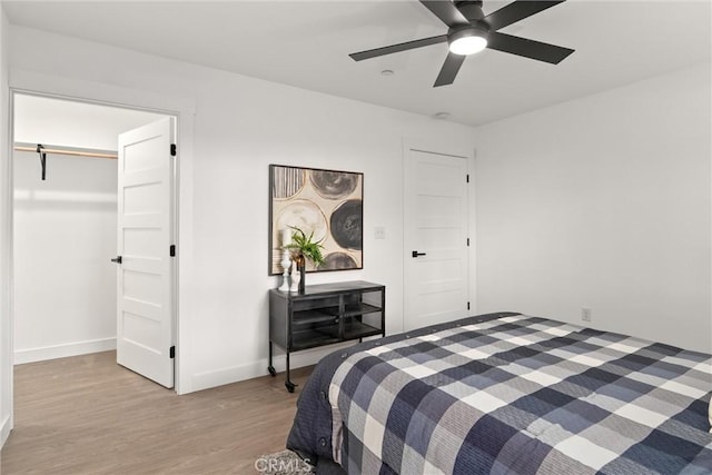 bedroom with wood finished floors, baseboards, and ceiling fan