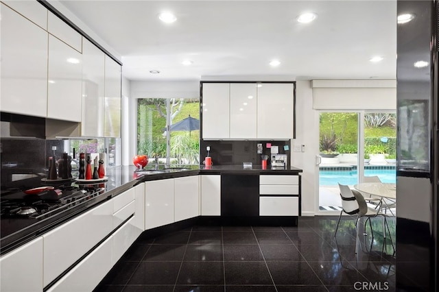 kitchen featuring recessed lighting, modern cabinets, white cabinets, and granite finish floor