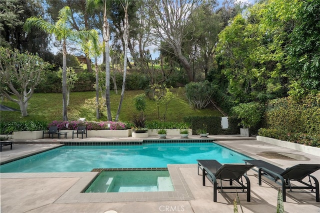 view of swimming pool with a patio area, a lawn, and a pool with connected hot tub