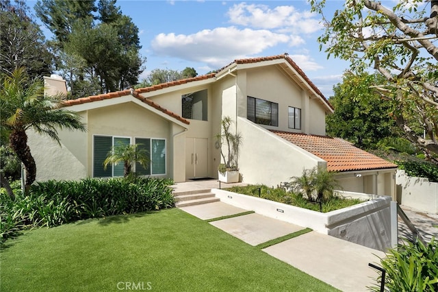 mediterranean / spanish-style house featuring fence, stucco siding, a front lawn, a garage, and a tile roof