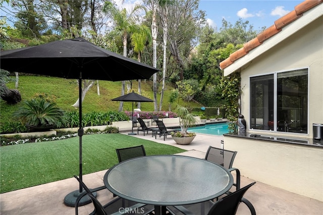 view of patio with an outdoor pool and outdoor dining space