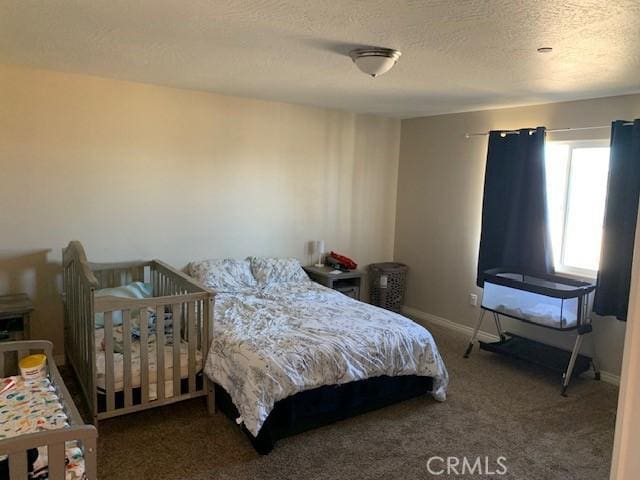 carpeted bedroom featuring a textured ceiling and baseboards