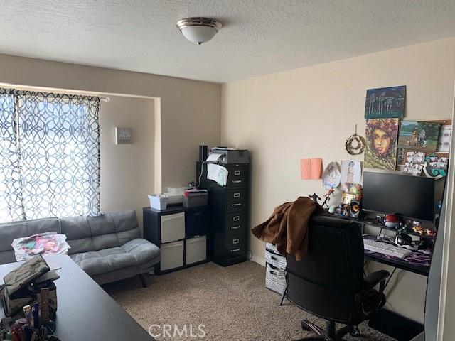 home office with carpet flooring and a textured ceiling