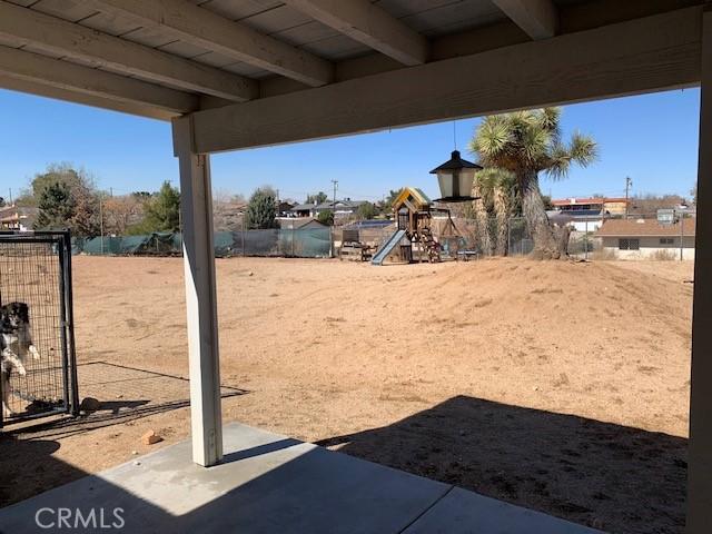 view of yard featuring fence, a patio area, and playground community