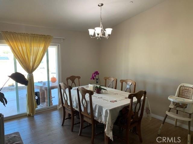 dining room with a chandelier, baseboards, and wood finished floors