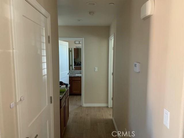 hallway featuring baseboards and light wood finished floors