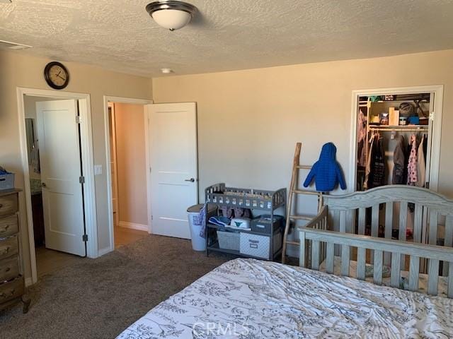 carpeted bedroom with a closet and a textured ceiling