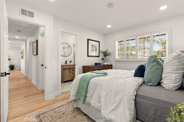 bedroom featuring visible vents, recessed lighting, light wood finished floors, baseboards, and attic access