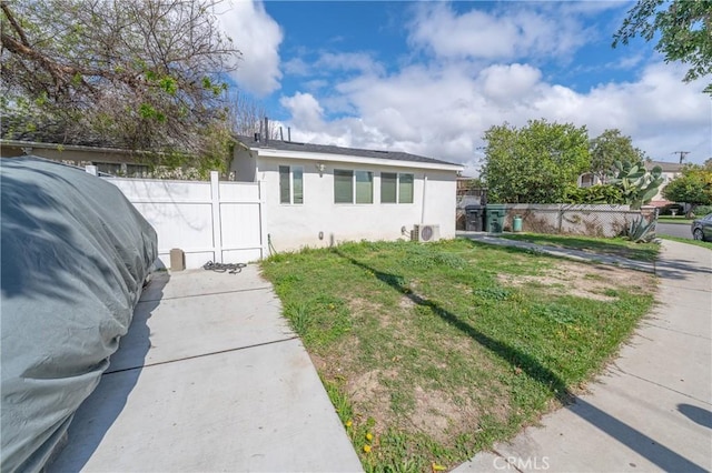 view of front of house featuring a front yard, ac unit, fence, and stucco siding