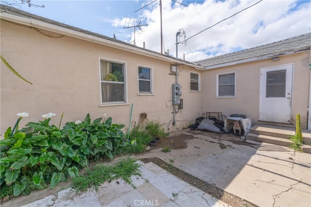 rear view of property with a patio area and stucco siding