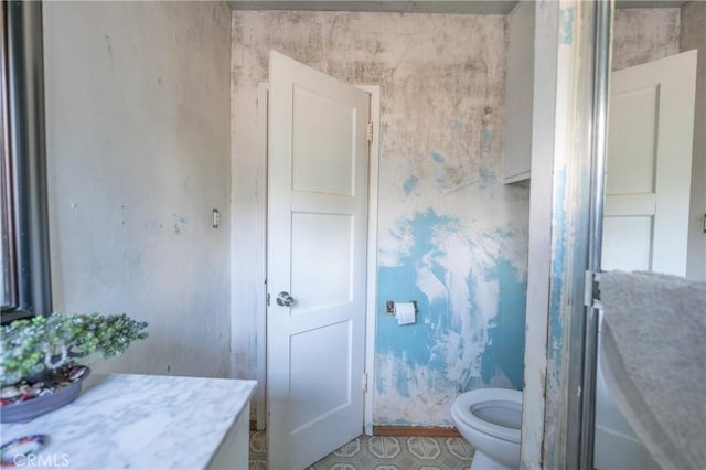 bathroom featuring wallpapered walls and toilet