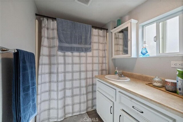 1301 Orange Ave, Chowchilla, CA 93610 - full bathroom with a shower with shower curtain, visible vents, and vanity