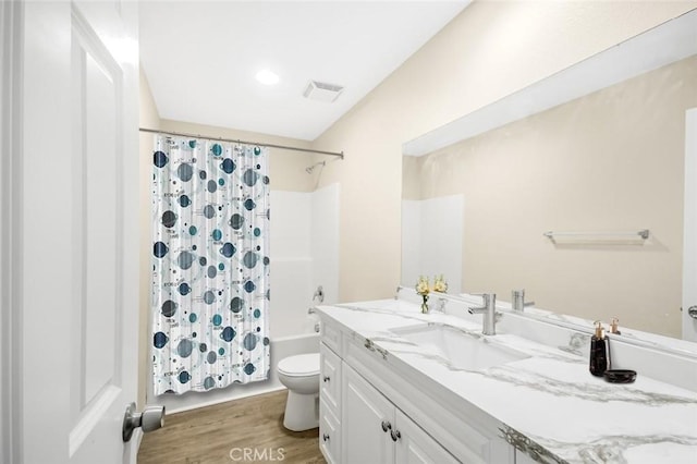 bathroom with visible vents, toilet, shower / bath combo, wood finished floors, and vanity