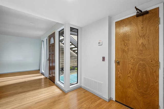 interior space with stairs, baseboards, visible vents, and light wood-type flooring