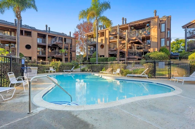 community pool featuring a patio and fence