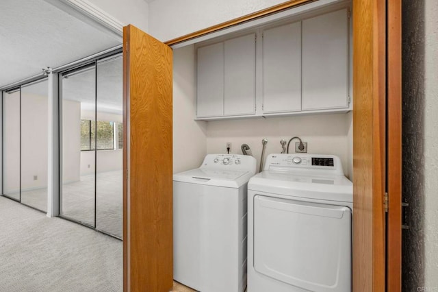 laundry room featuring light carpet, cabinet space, and washing machine and clothes dryer