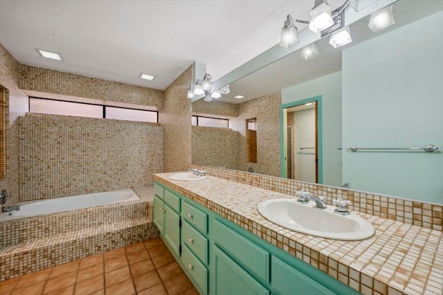 bathroom featuring tile patterned flooring, double vanity, a garden tub, and a sink