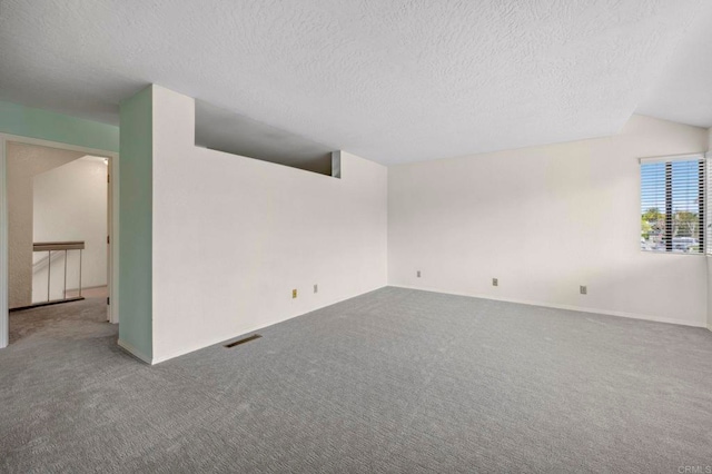 spare room with visible vents, carpet floors, and a textured ceiling