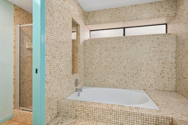 full bath featuring tile patterned floors, a garden tub, and a stall shower