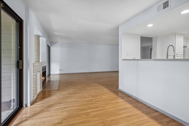 4015 Canario St Unit D, Carlsbad, CA 92008 - unfurnished living room with light wood finished floors, a fireplace, and recessed lighting