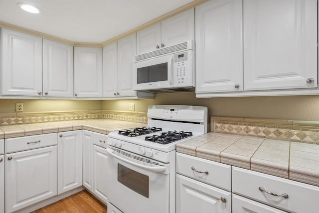 4015 Canario St Unit D, Carlsbad, CA 92008 - kitchen featuring white appliances, white cabinetry, light wood-style floors, and recessed lighting