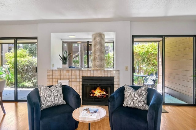 4015 Canario St Unit D, Carlsbad, CA 92008 - living room featuring wood finished floors, a tiled fireplace, and a textured ceiling