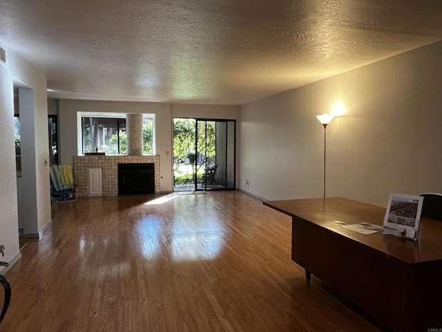 4015 Canario St Unit D, Carlsbad, CA 92008 - unfurnished living room with wood finished floors, a fireplace, and a textured ceiling