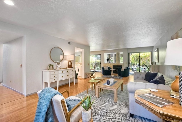 4015 Canario St Unit D, Carlsbad, CA 92008 - living room with light wood-style flooring, a fireplace, and a textured ceiling
