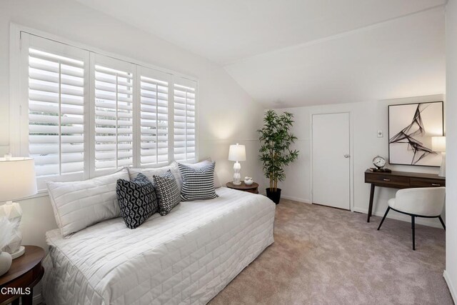 carpeted bedroom featuring lofted ceiling