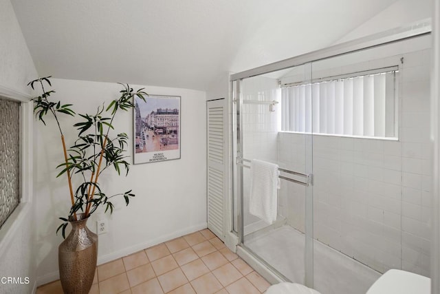 full bath featuring lofted ceiling, toilet, a stall shower, and tile patterned flooring