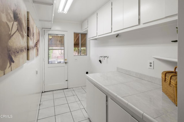 laundry area with light tile patterned flooring, cabinet space, and washer hookup