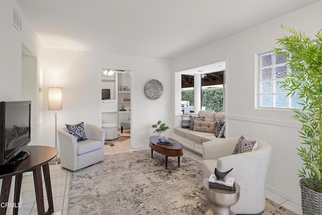 living area with light tile patterned floors, visible vents, and a ceiling fan