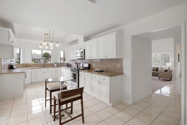 kitchen featuring light tile patterned floors, a healthy amount of sunlight, appliances with stainless steel finishes, and a sink