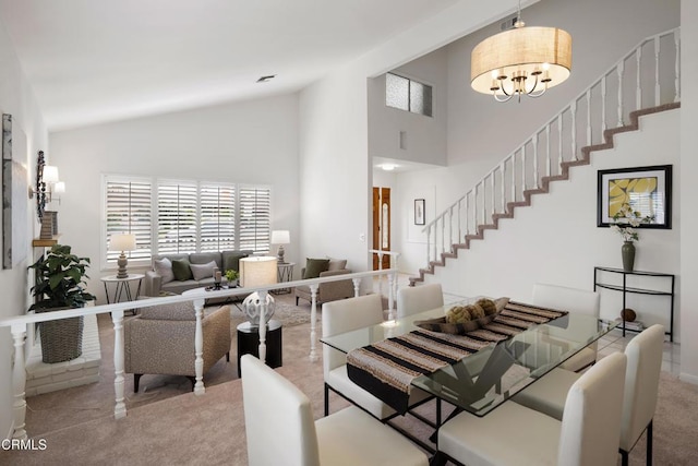 carpeted dining room with visible vents, high vaulted ceiling, a chandelier, and stairs