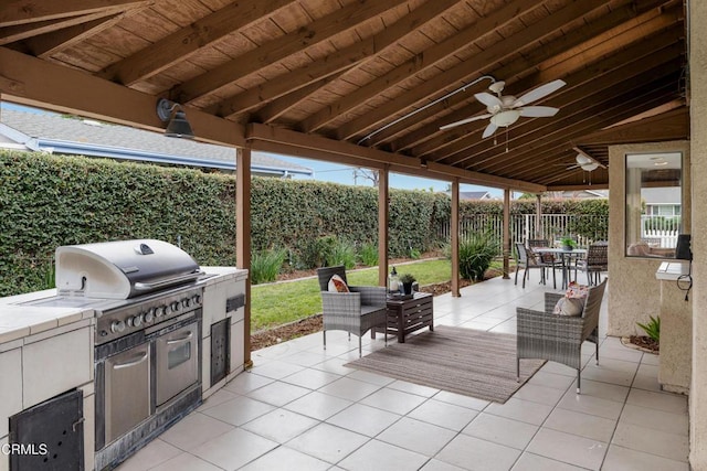 view of patio featuring a ceiling fan, area for grilling, a fenced backyard, and a grill