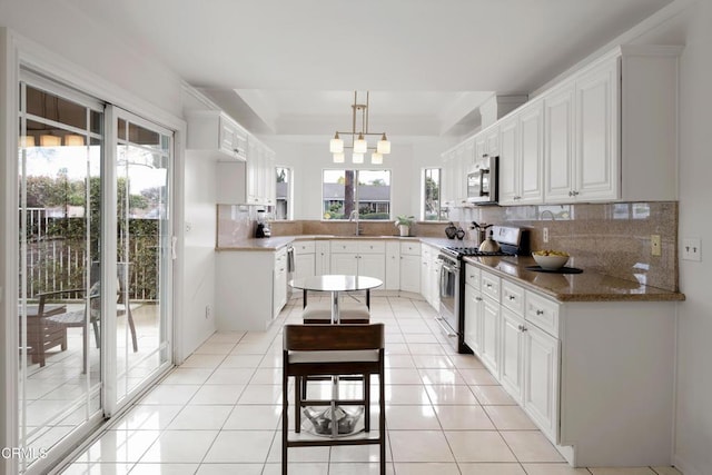 kitchen featuring tasteful backsplash, light tile patterned floors, white cabinets, and stainless steel appliances