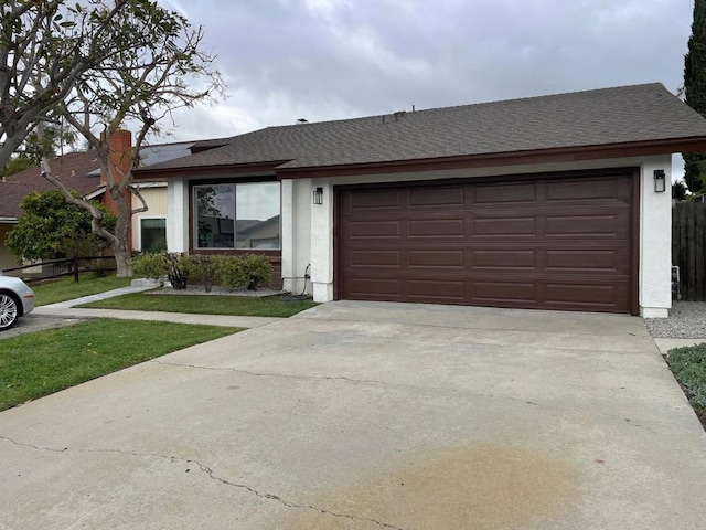 ranch-style home featuring stucco siding, fence, concrete driveway, a shingled roof, and a garage