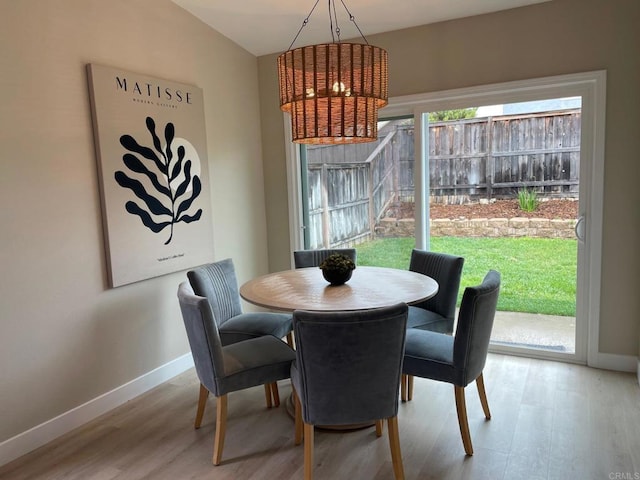 dining area featuring a wealth of natural light, a chandelier, baseboards, and wood finished floors