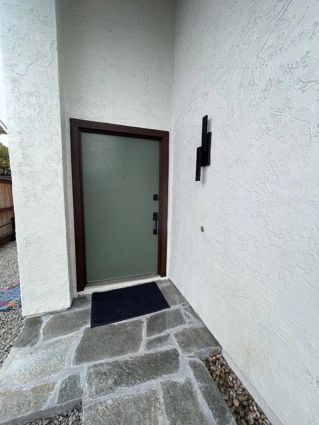 property entrance with stucco siding