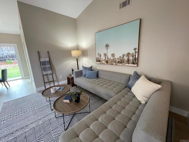 living area with visible vents, baseboards, and wood finished floors