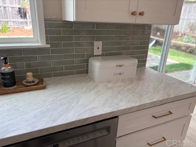 details with light stone counters, dishwasher, and white cabinetry