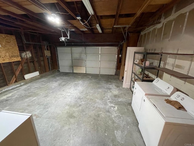 garage with a garage door opener and independent washer and dryer