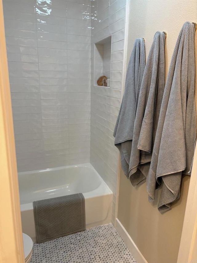 bathroom featuring tile patterned floors, shower / bathing tub combination, baseboards, and toilet