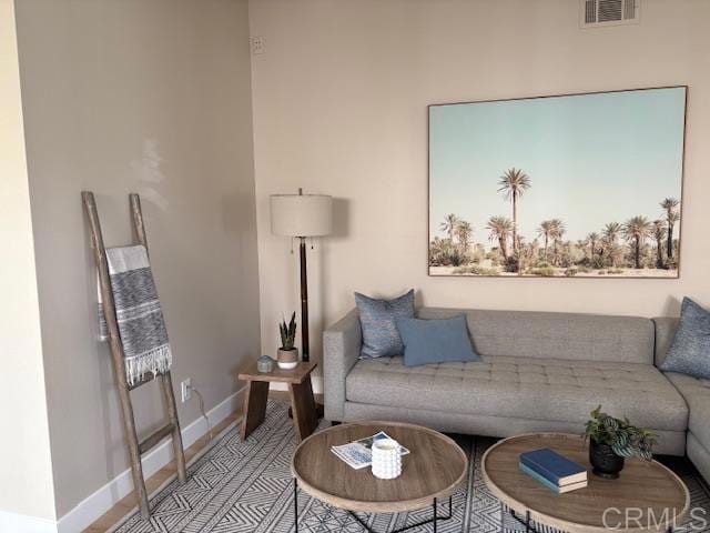 living room featuring baseboards and visible vents